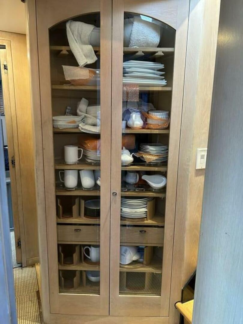 a cupboard with many dishes on it aboard TOTO Yacht for Sale