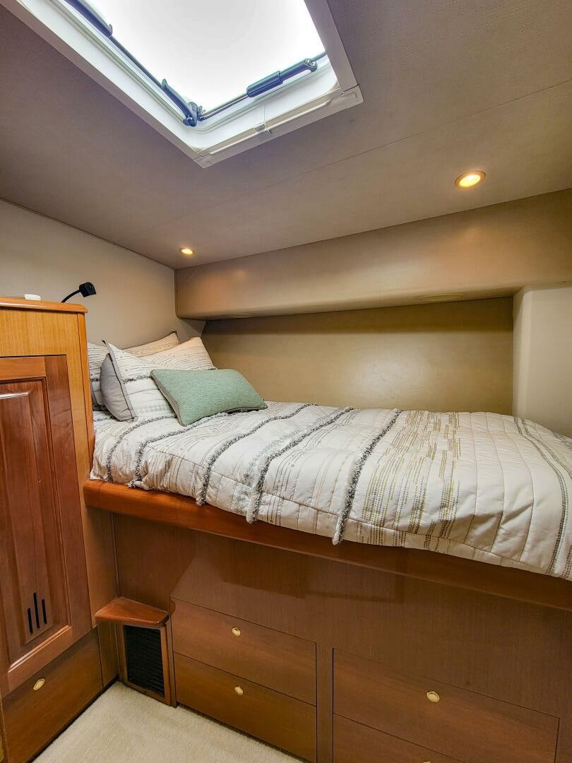 a bed with a white comforter aboard PRIME TIME Yacht for Sale