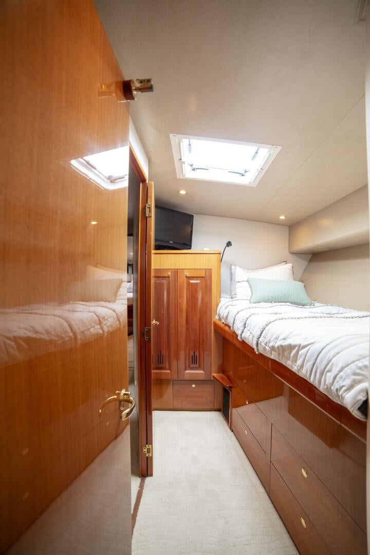 a bedroom with a bed and a television aboard PRIME TIME Yacht for Sale