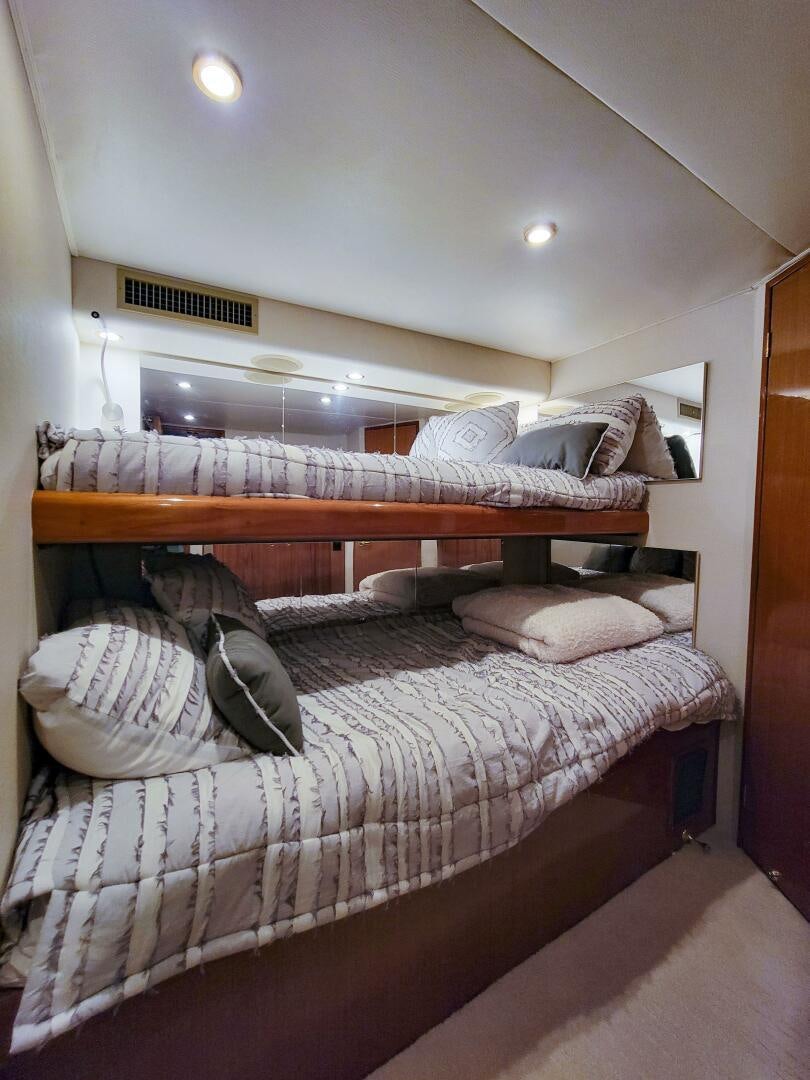 a bed with a white sheet and pillows on it aboard PRIME TIME Yacht for Sale