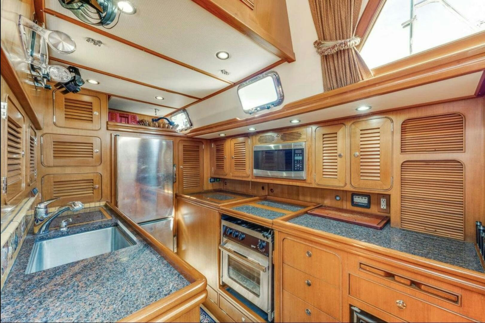 a kitchen with wooden cabinets aboard PERFECT SYMMETRY 5 Yacht for Sale