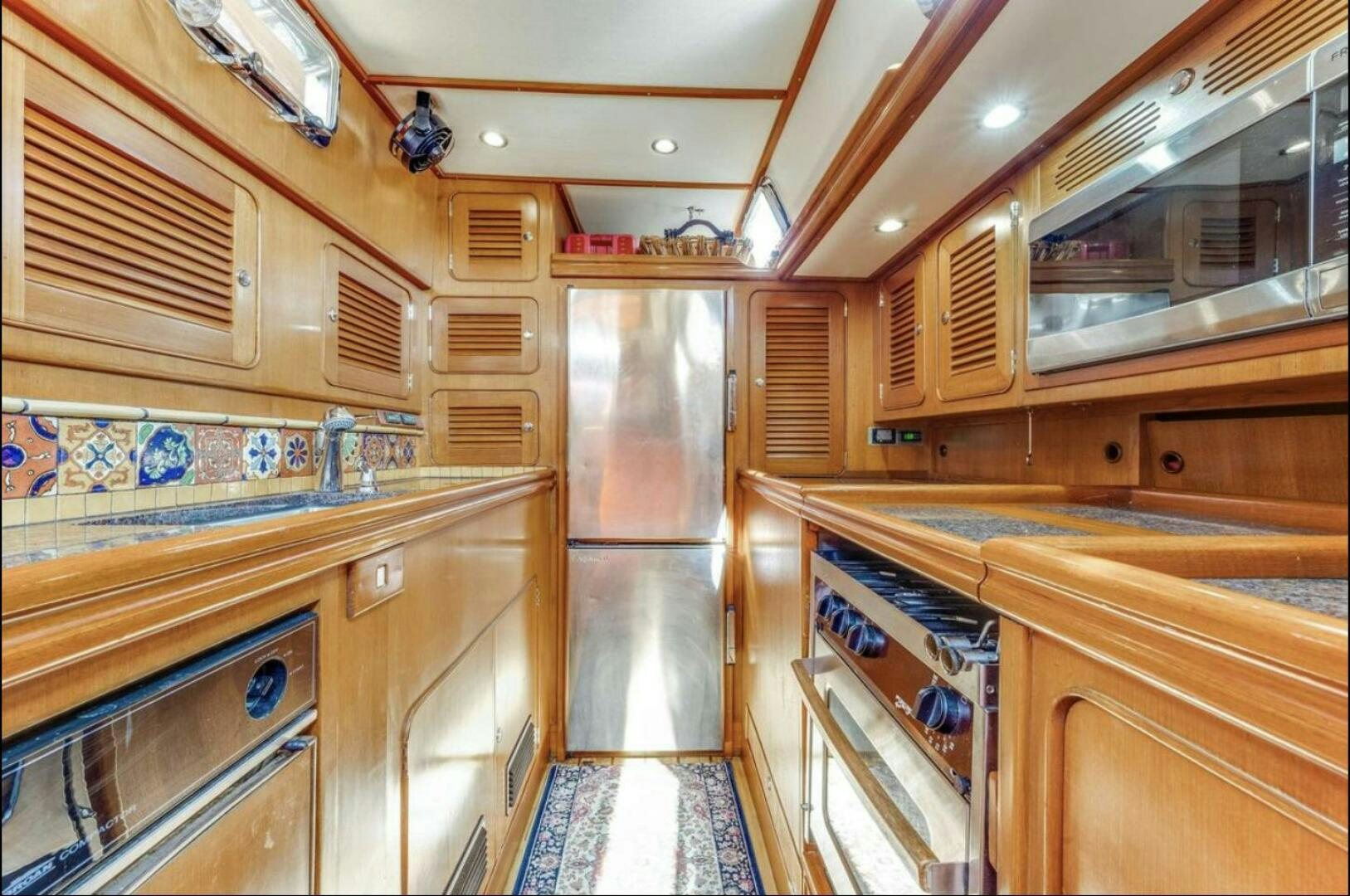 a large kitchen with wooden cabinets aboard PERFECT SYMMETRY 5 Yacht for Sale