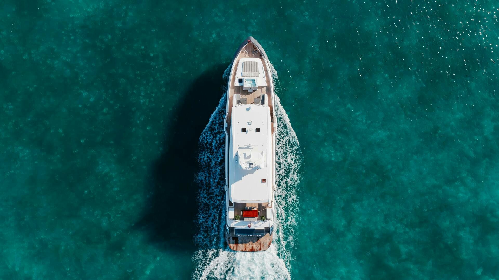 a white ship in the water aboard UNTETHERED Yacht for Sale