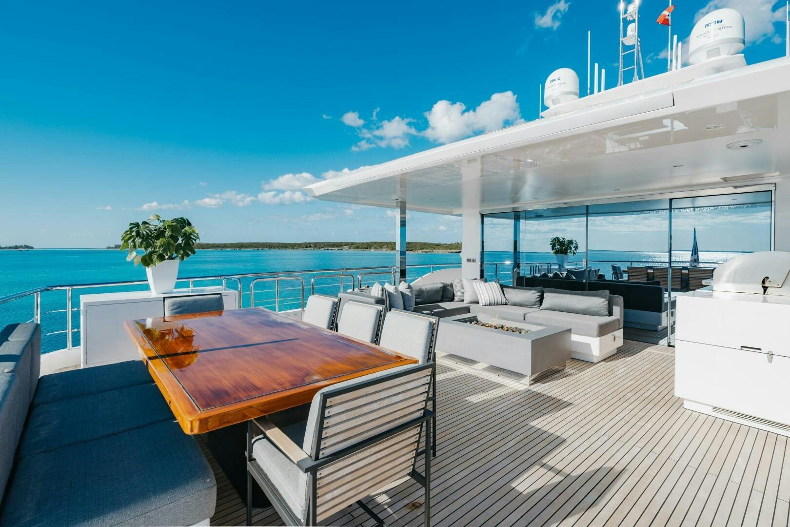 a deck with a table and chairs on it aboard UNTETHERED Yacht for Sale