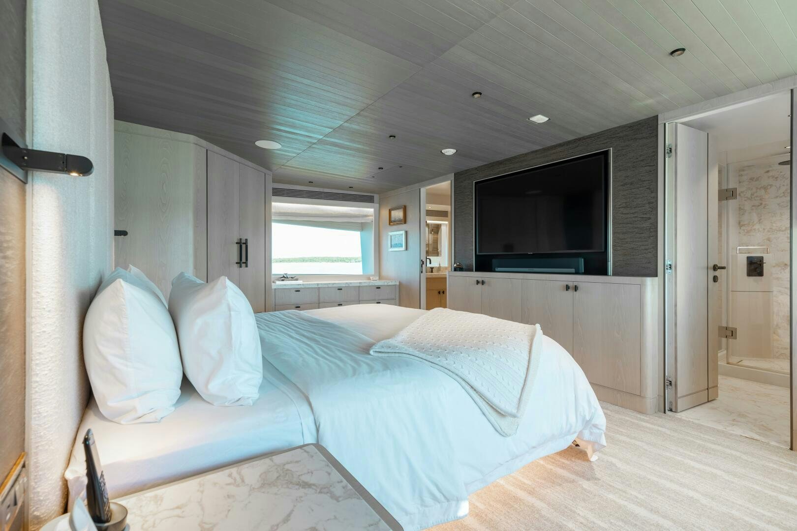 a bedroom with a bed and a tv aboard UNTETHERED Yacht for Sale