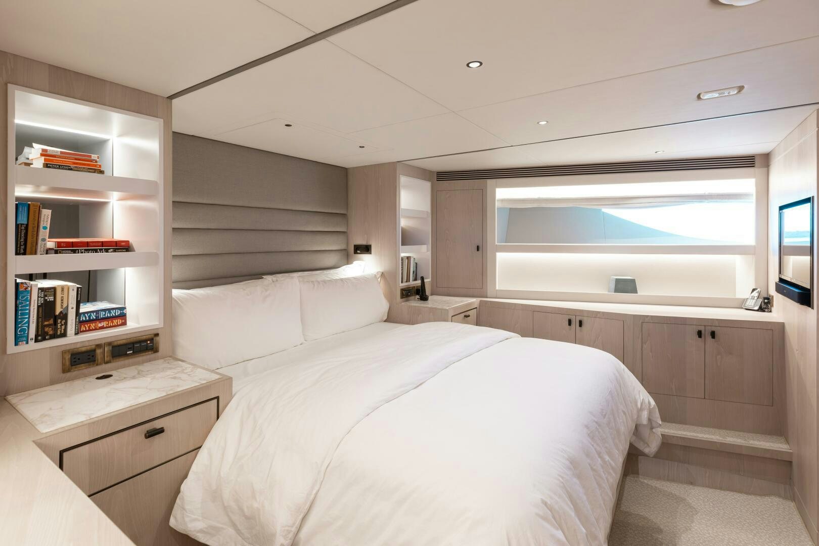 a bedroom with a bed and a window aboard UNTETHERED Yacht for Sale