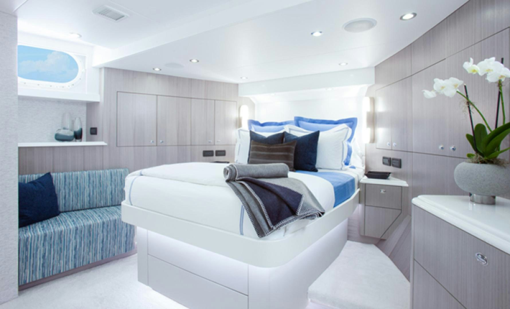 a white bedroom with a blue bed aboard HANNAH Yacht for Sale