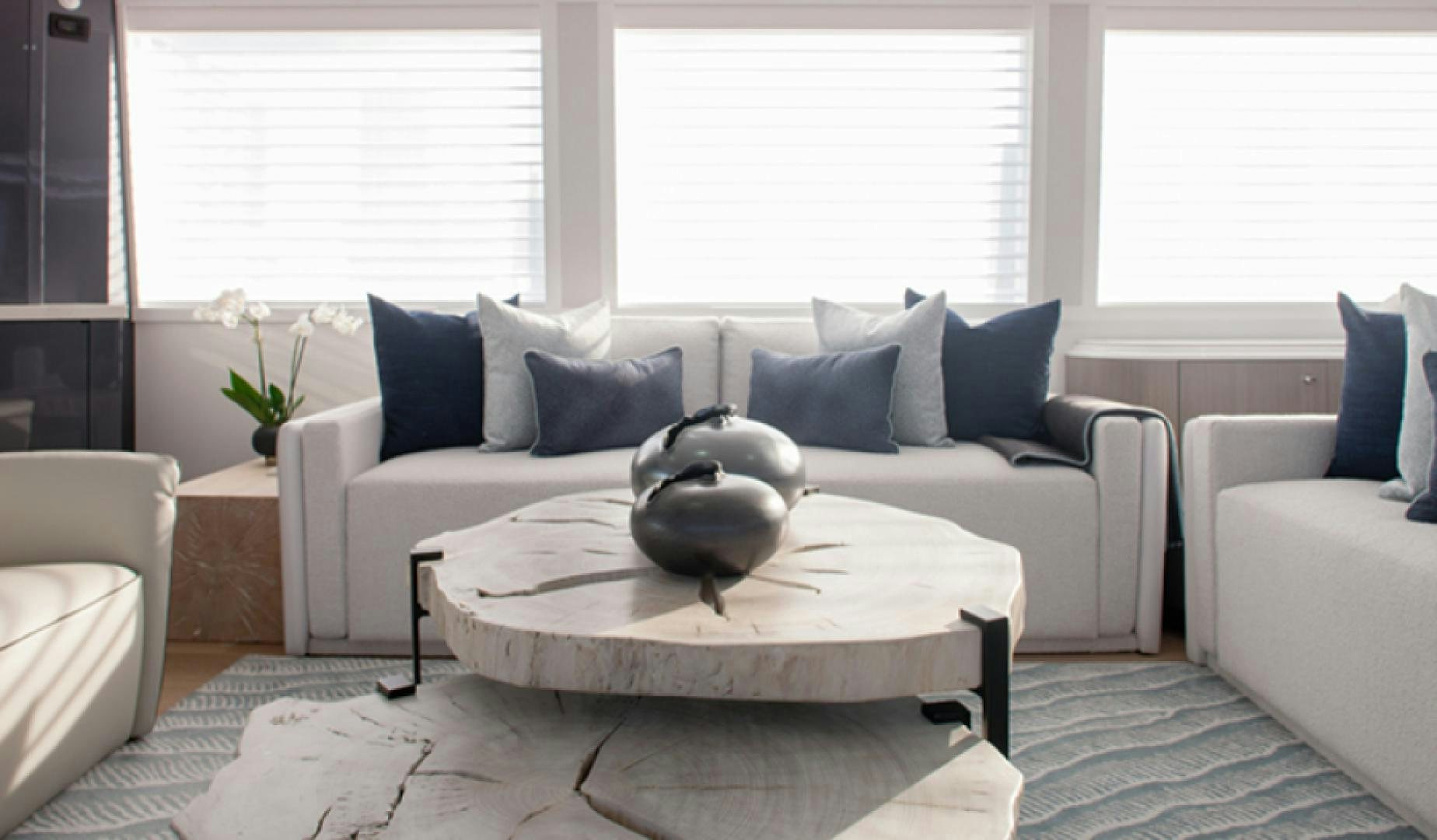 a white couch with a round coffee table and a white coffee table with blue pillows and a white aboard HANNAH Yacht for Sale