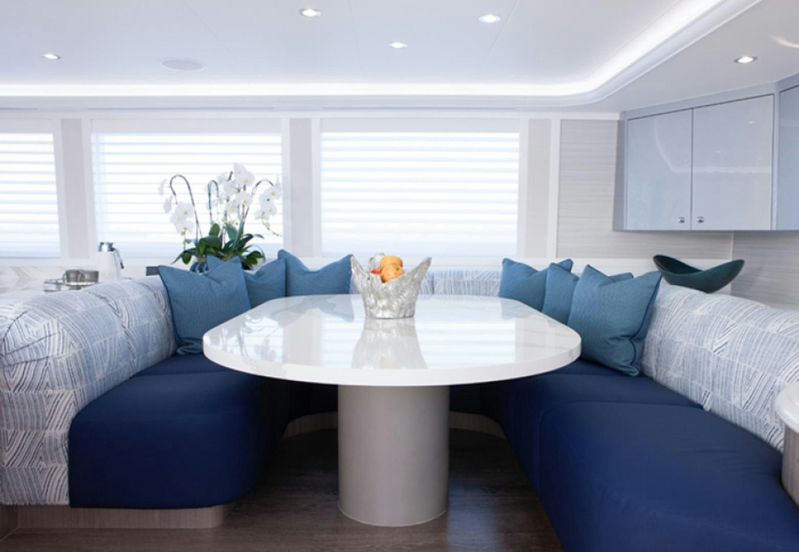 a living room with a blue couch and white cabinets aboard HANNAH Yacht for Sale