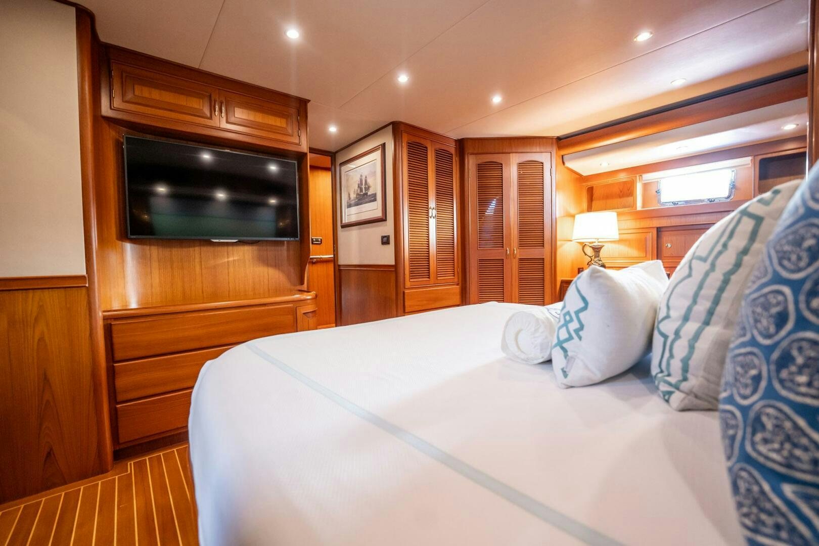 a bed with pillows and a television aboard BEBA Yacht for Sale