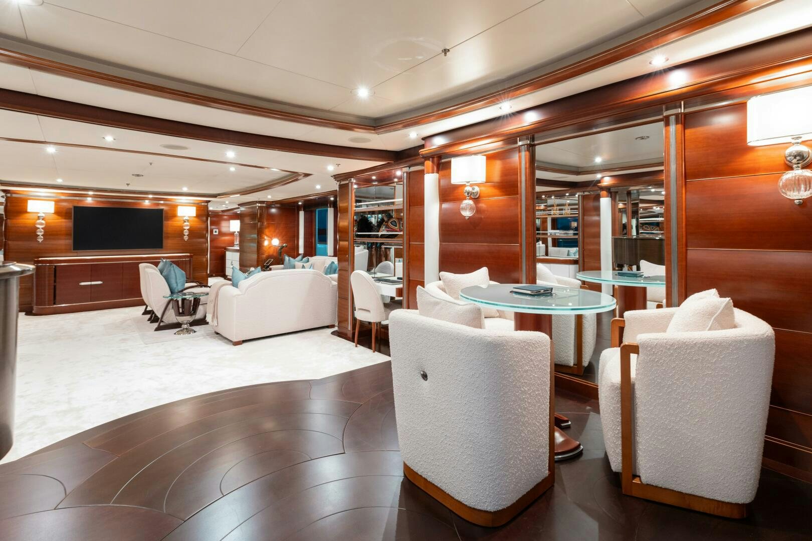a room with a table chairs and a couch aboard Q Yacht for Sale