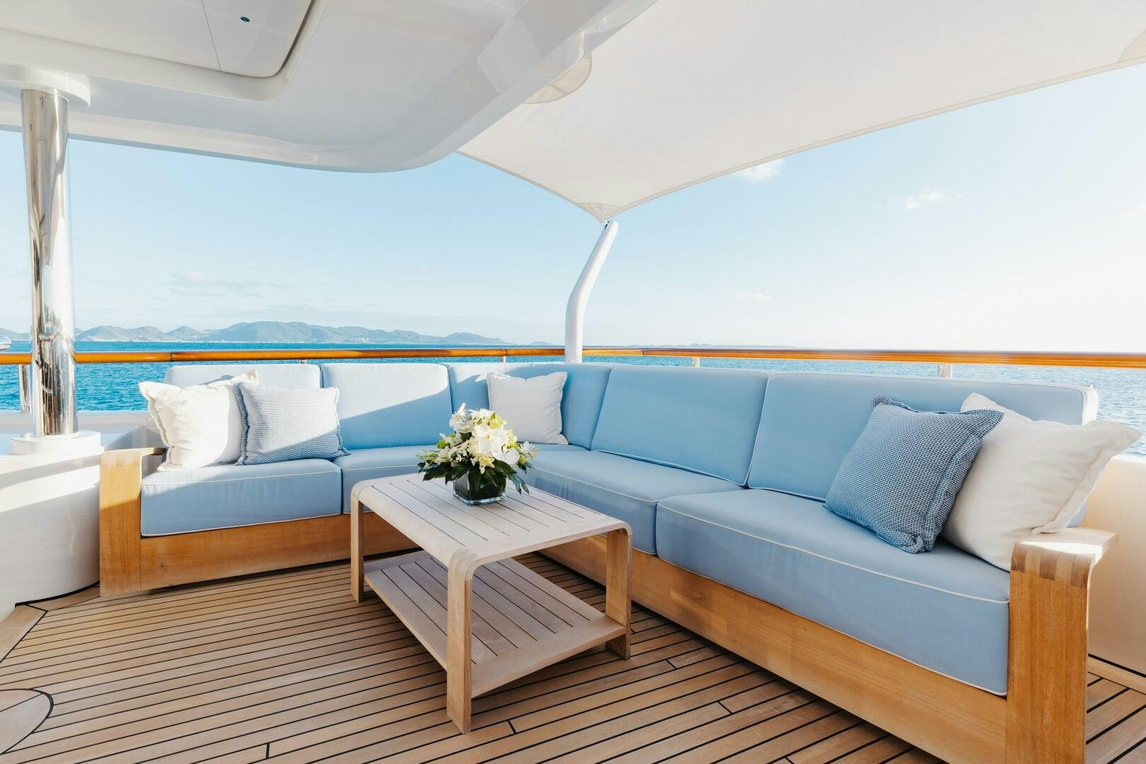 a blue couch with white pillows aboard Q Yacht for Sale