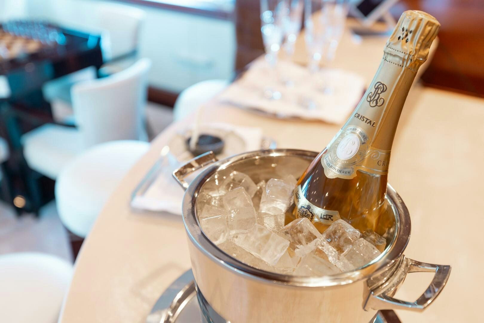 a bottle of alcohol on a table aboard Q Yacht for Sale