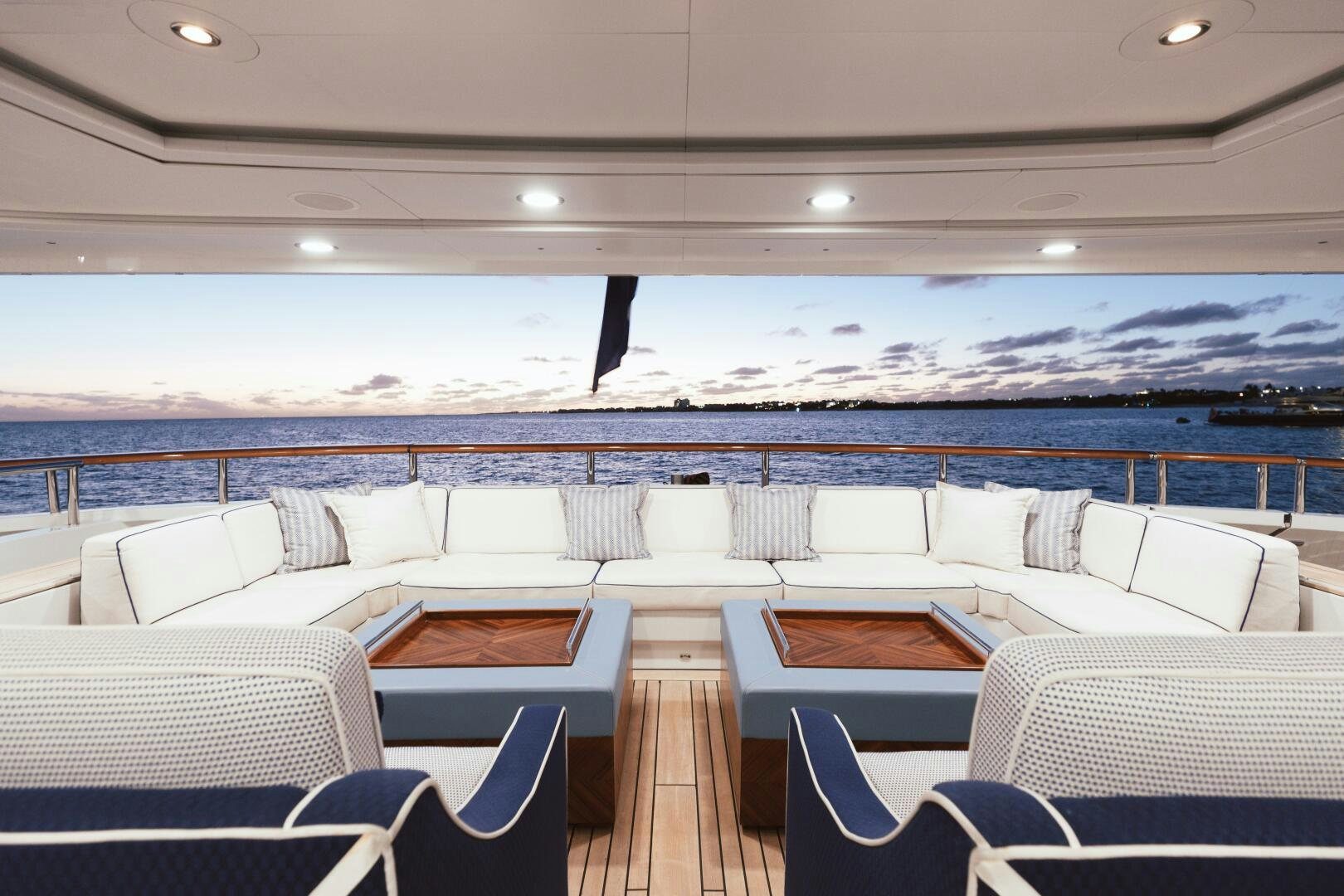 a room with chairs and a large body of water in the background aboard Q Yacht for Sale