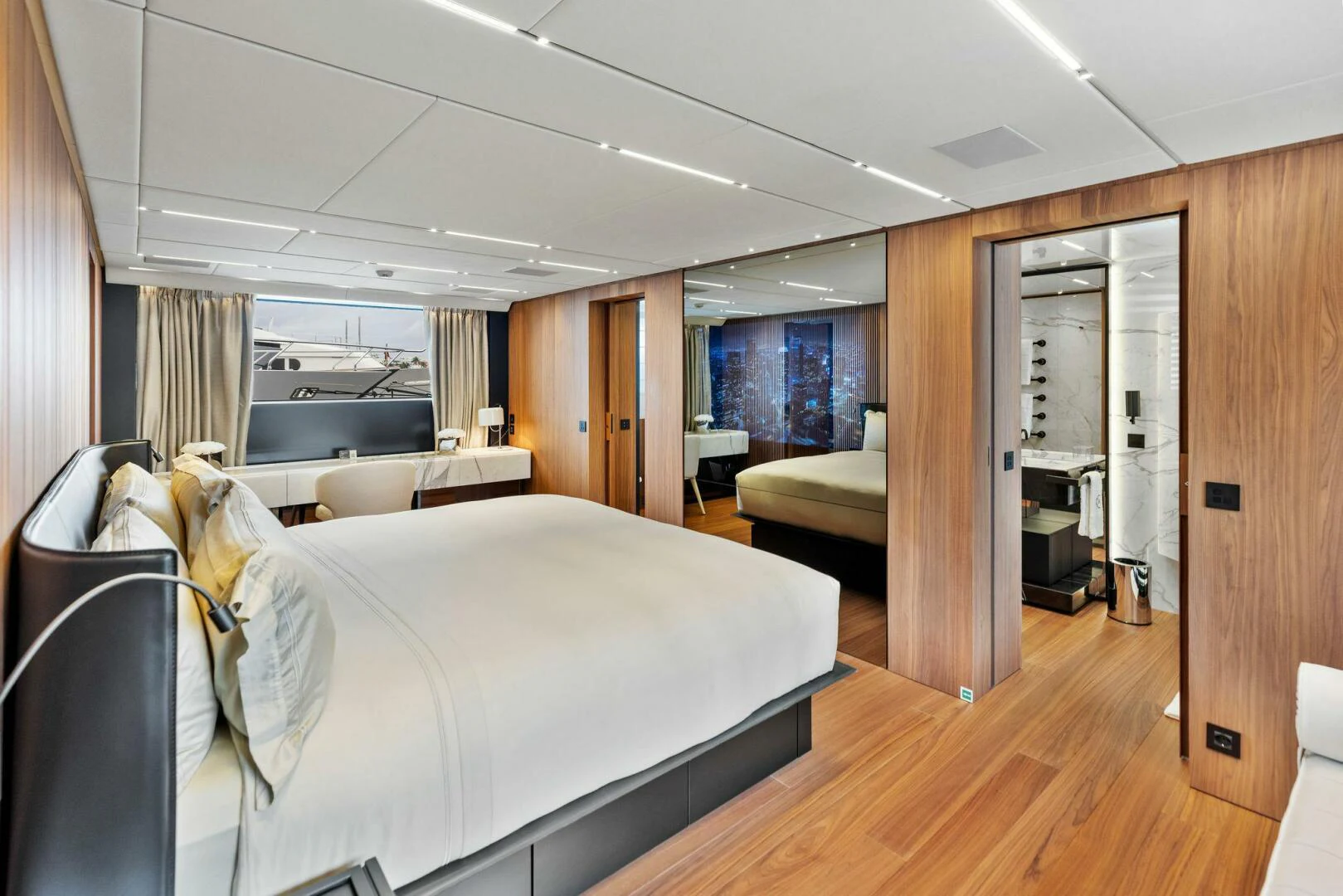 a room with a bed and a wood floor aboard KAMAKASA Yacht for Sale