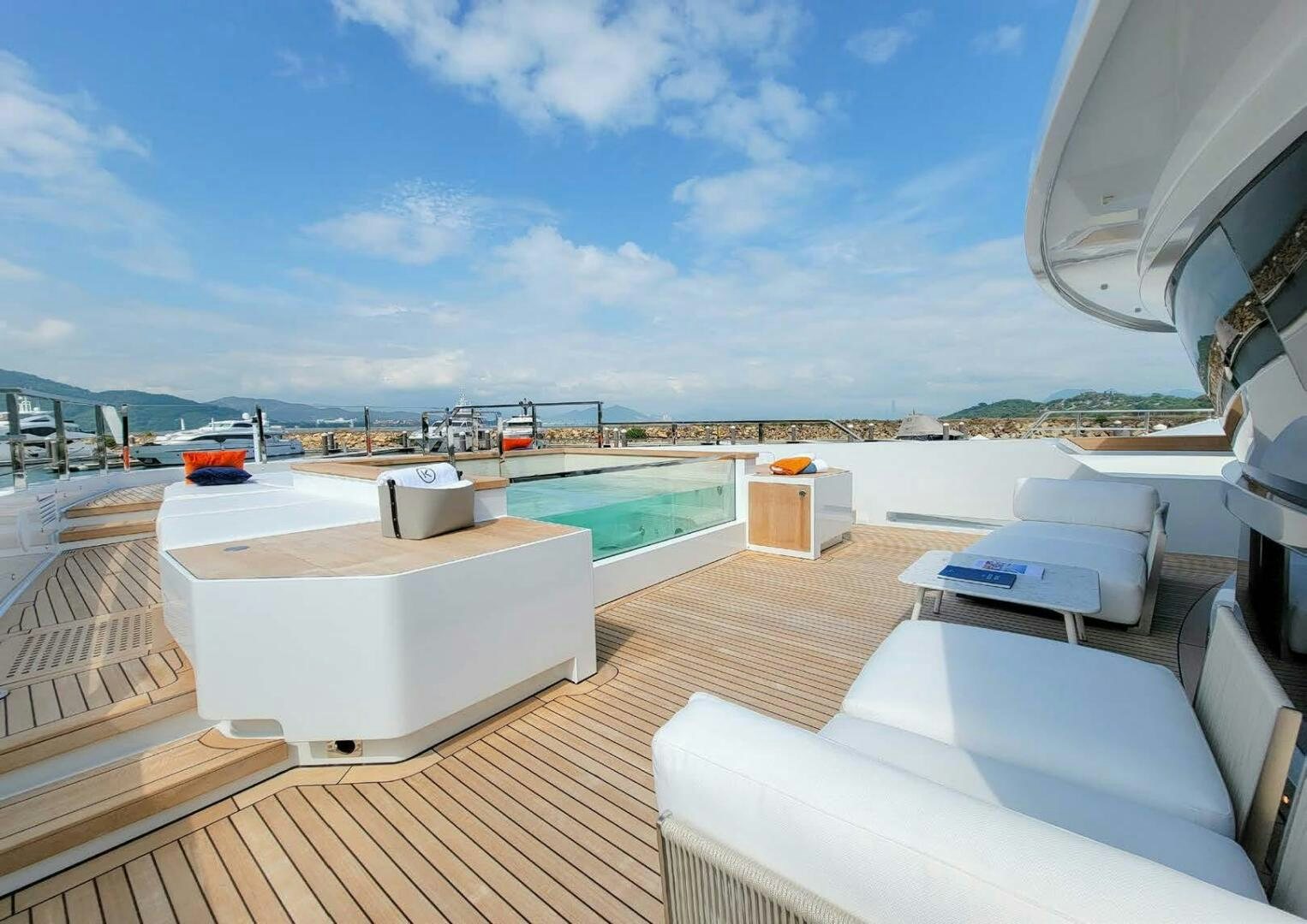 a deck with a pool and a view of the water aboard KAMAKASA Yacht for Sale
