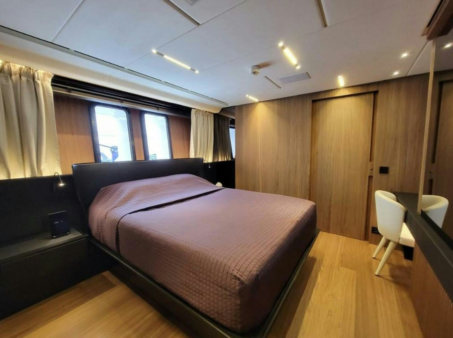 a room with a bed and a chair aboard KAMAKASA Yacht for Sale