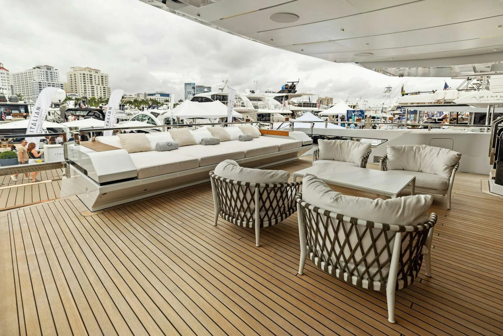 a room with a group of couches and a large white bed aboard KAMAKASA Yacht for Sale