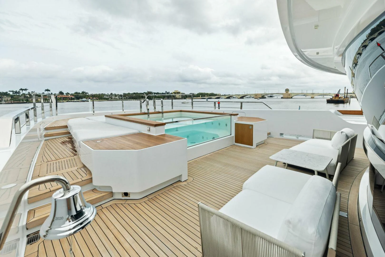 a deck with a pool and a deck overlooking a beach aboard KAMAKASA Yacht for Sale