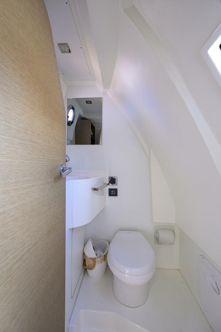 a small bathroom with a toilet and sink aboard 2016 68 PRESTIGE Yacht for Sale