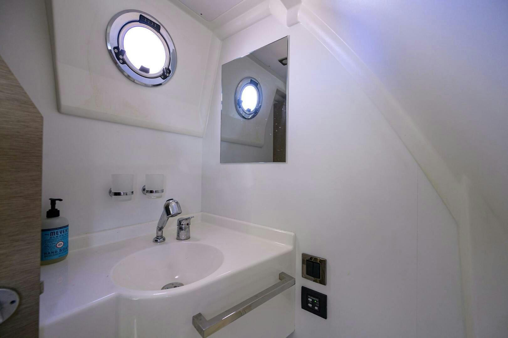 a bathroom with a sink and a mirror aboard 2016 68 PRESTIGE Yacht for Sale