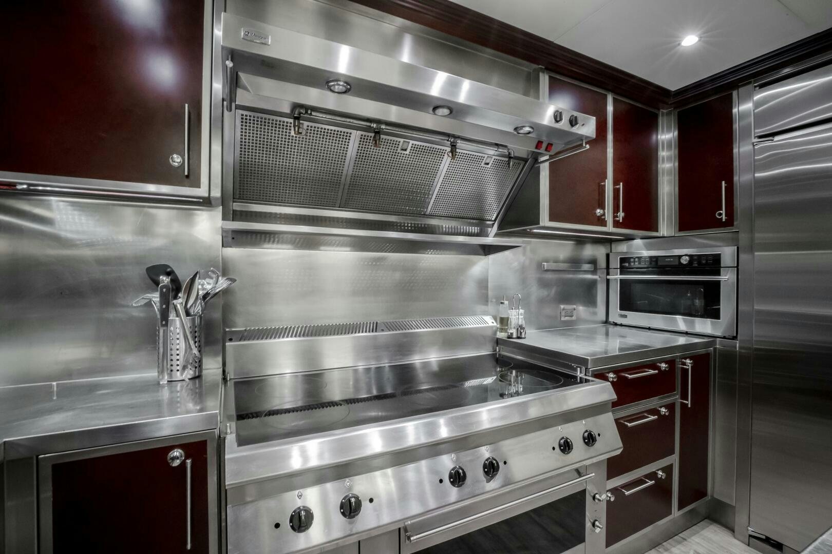 a kitchen with red cabinets aboard STATUS QUO Yacht for Sale