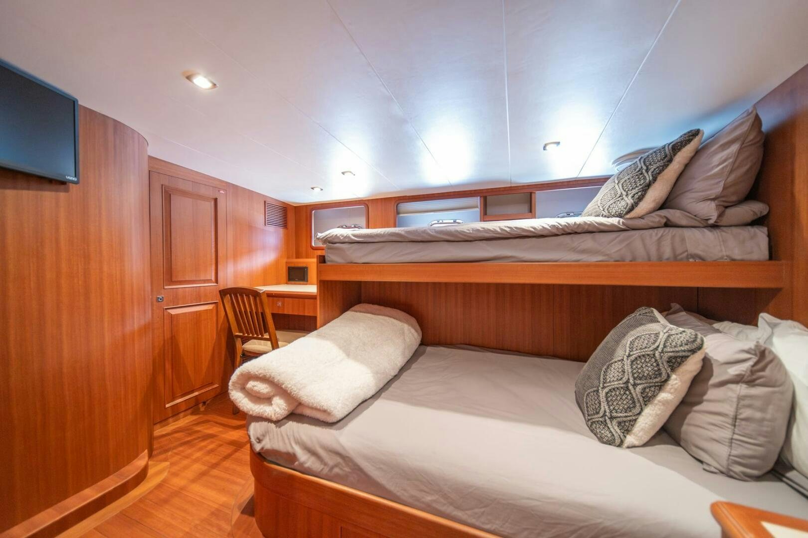 a bedroom with a bed and a wood cabinet aboard ABRI SUR LA MER Yacht for Sale