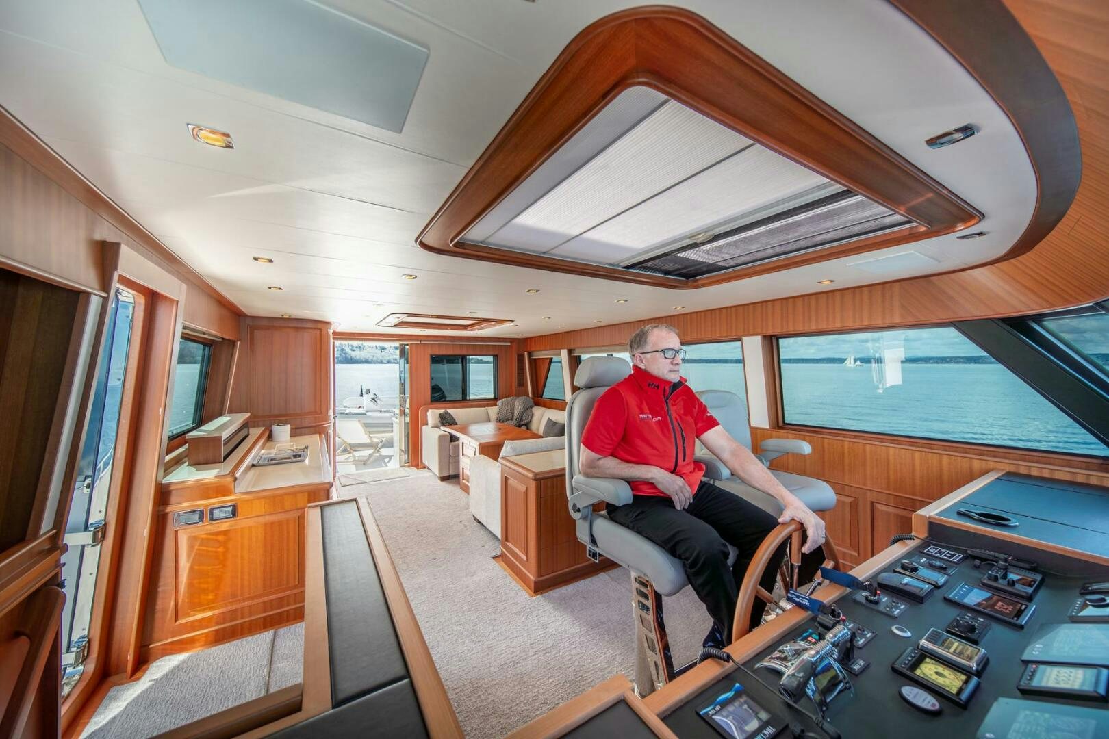 a person sitting in a chair in a room with a large window aboard ABRI SUR LA MER Yacht for Sale