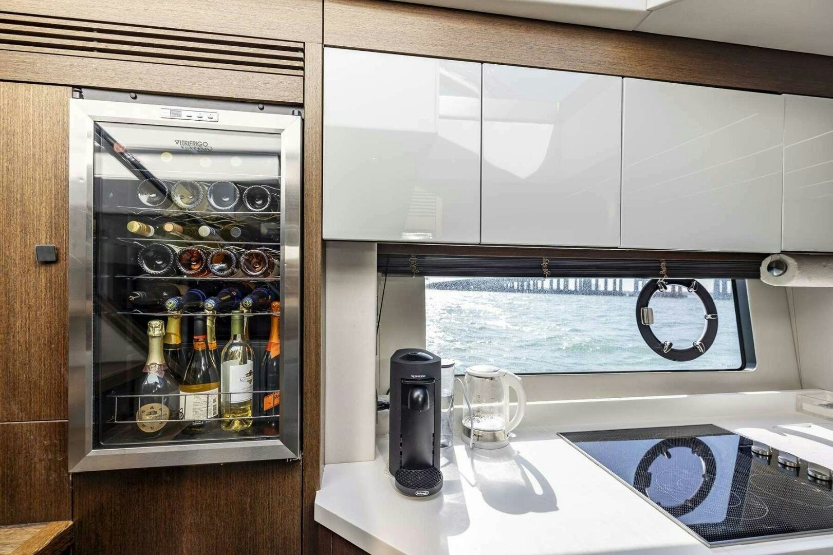 a glass bottle and a glass of wine in a kitchen aboard H Yacht for Sale