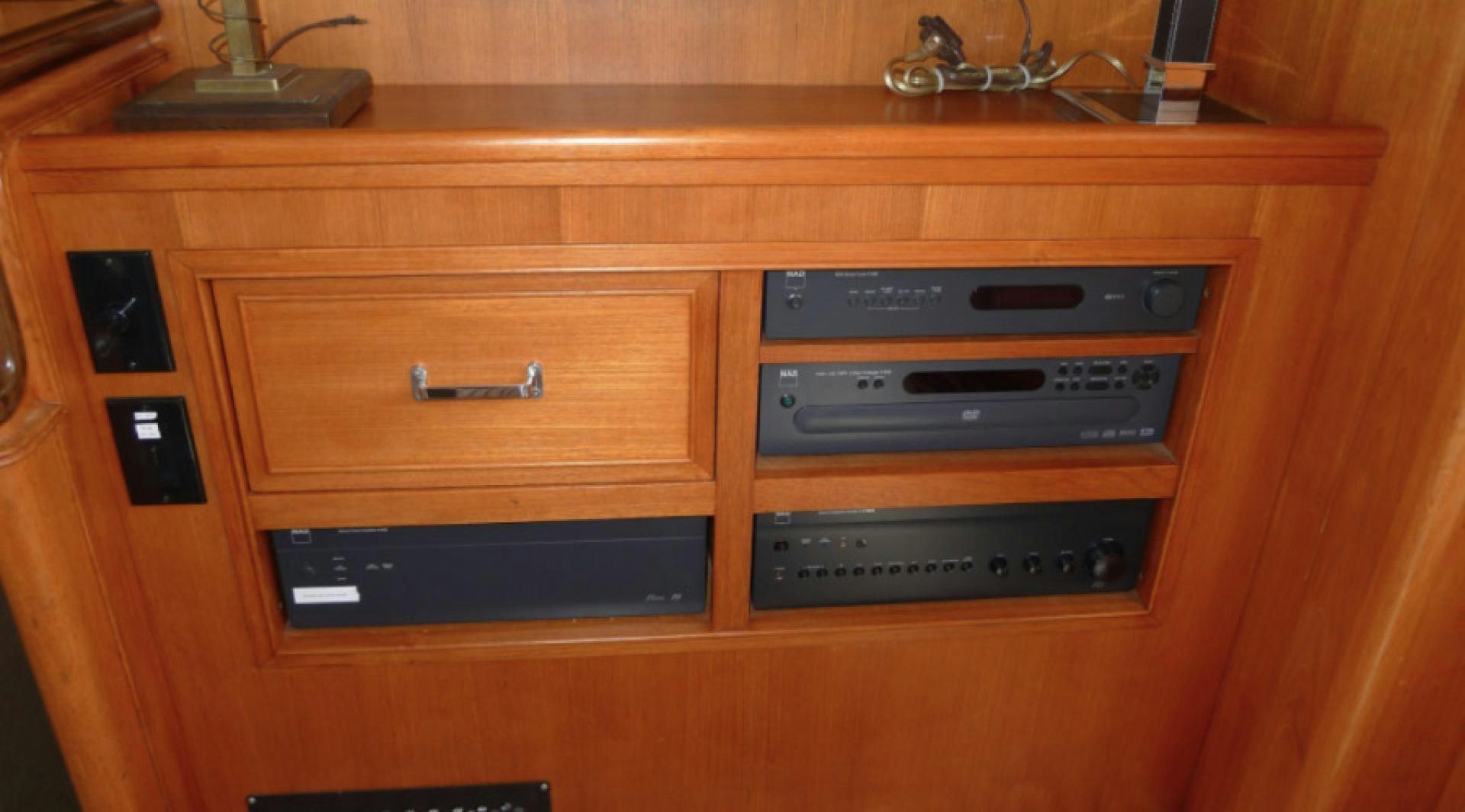 a wooden shelf with black drawers aboard DAKOTA Yacht for Sale