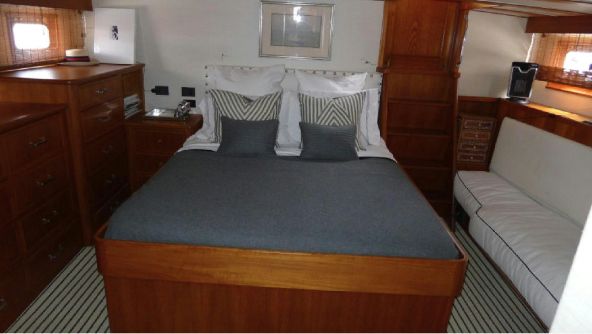 a bed with a blue comforter aboard DAKOTA Yacht for Sale