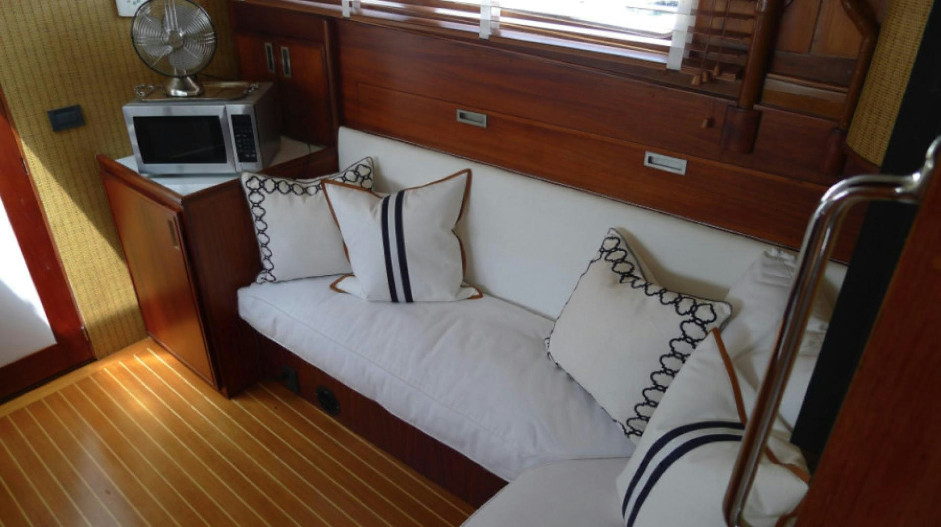 a bed with a white couch aboard DAKOTA Yacht for Sale