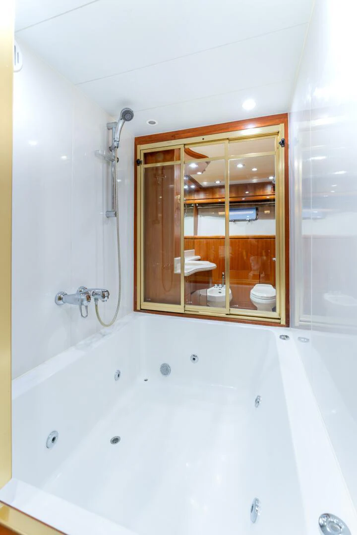 a bathroom with a tub and a mirror aboard UN WINE Yacht for Sale