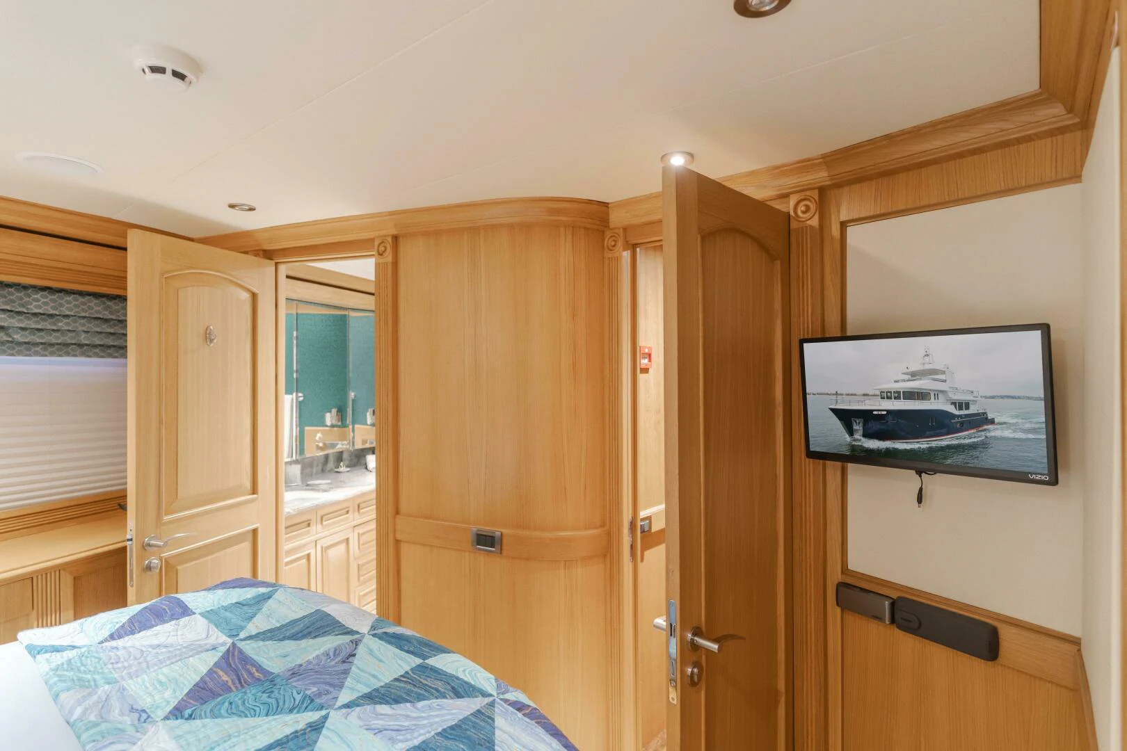 a bedroom with a bed and a television aboard UNDAUNTED Yacht for Sale