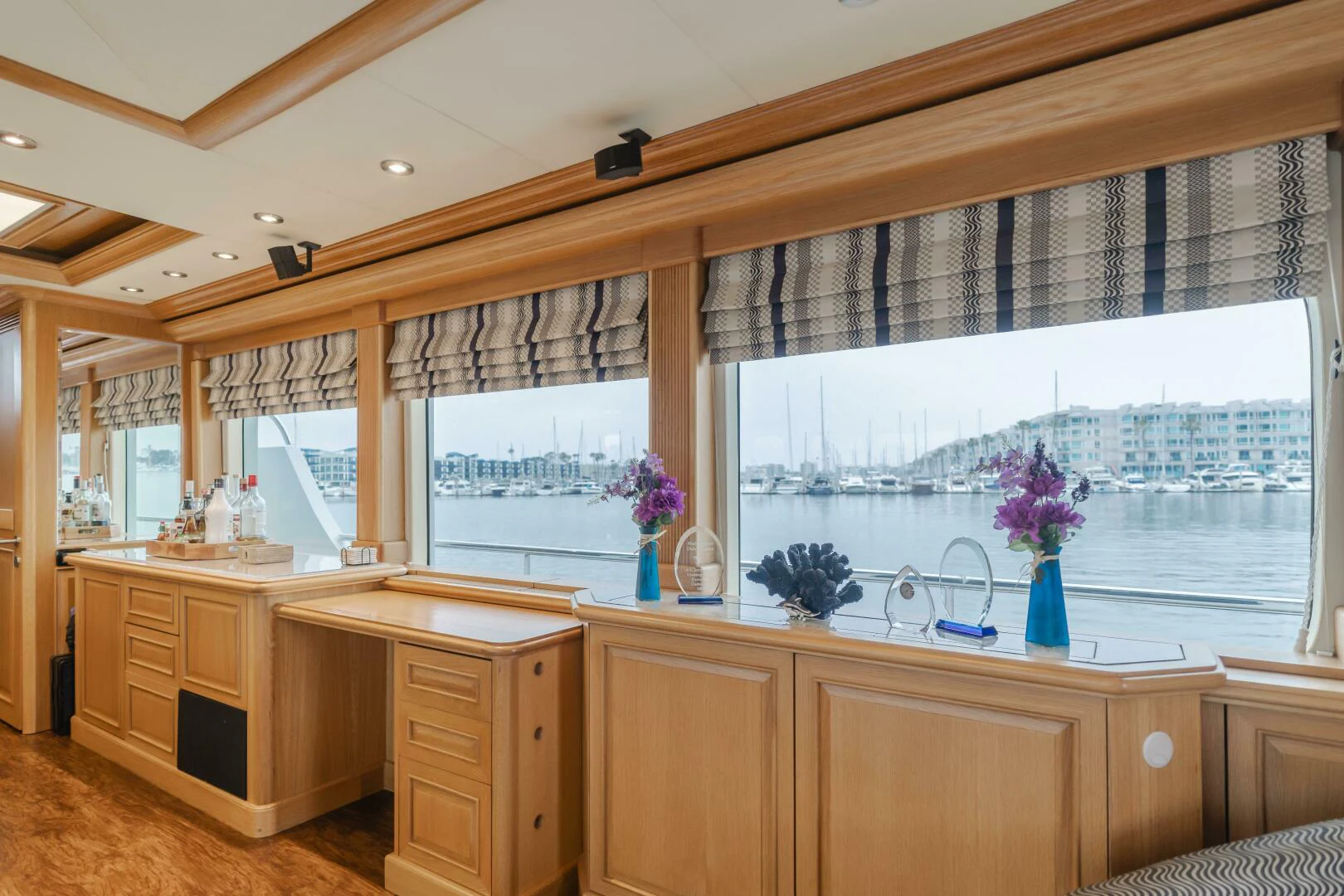 a room with a window and a desk with a vase of flowers aboard UNDAUNTED Yacht for Sale
