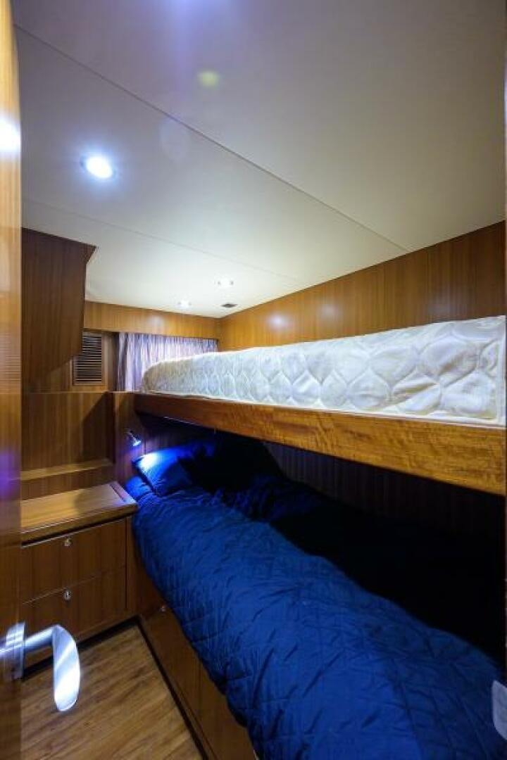 a room with a bed and a wood cabinet aboard BARNSTAR Yacht for Sale