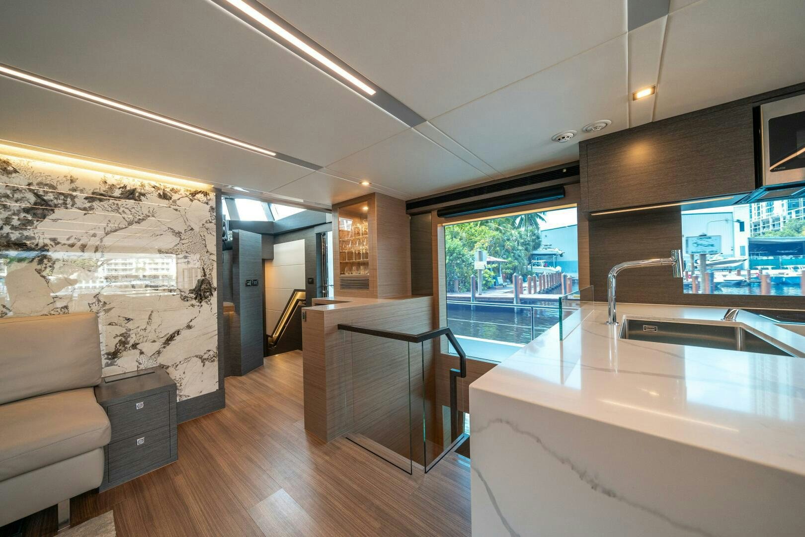 a room with a wood floor and a large window with a view of the city aboard AFTER MIDNIGHT Yacht for Sale