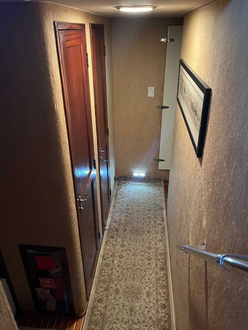 a hallway with a door and a rug aboard LADY T Yacht for Sale
