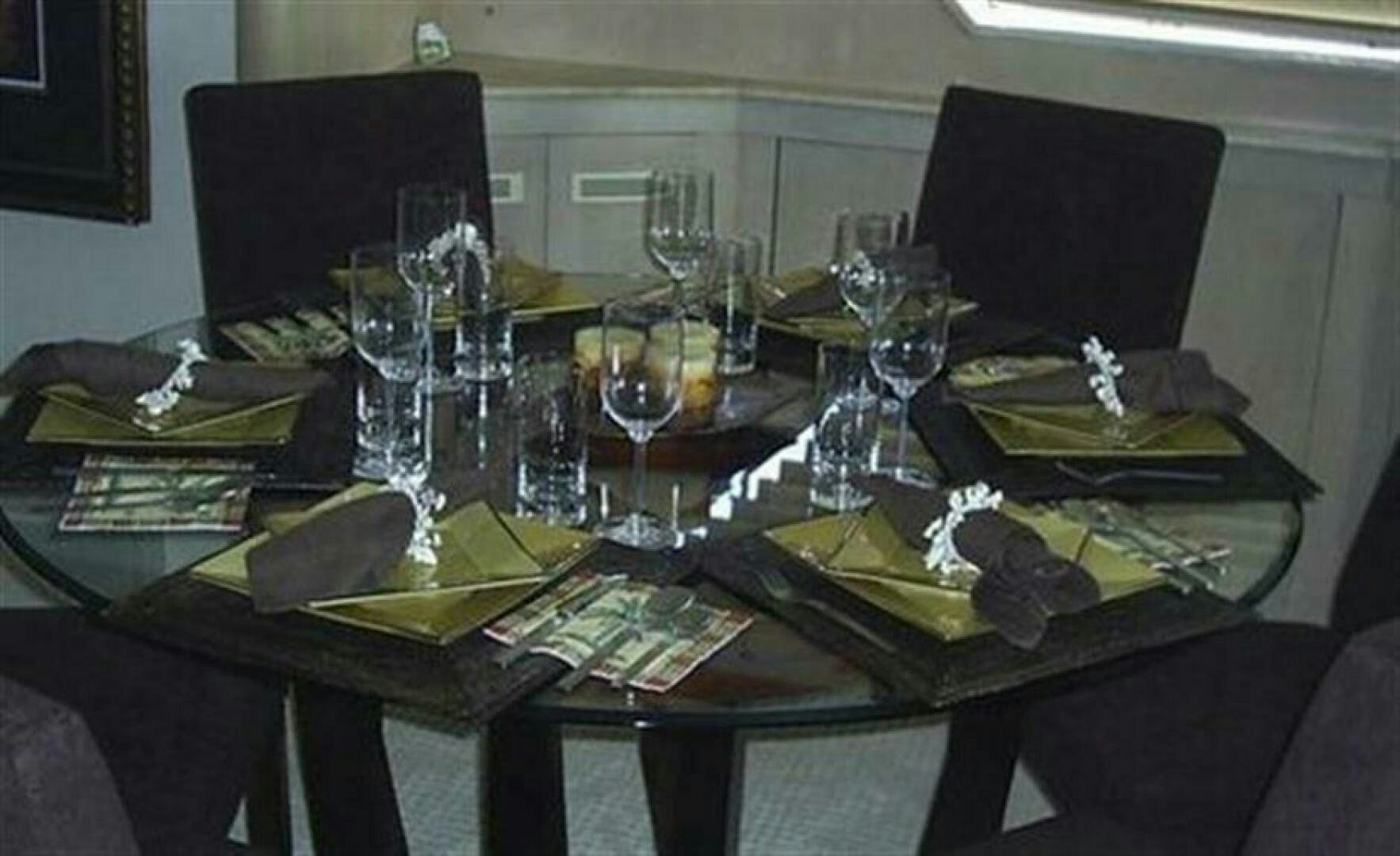 a table with a plate of food and glasses on it aboard THE BEST DAY Yacht for Sale