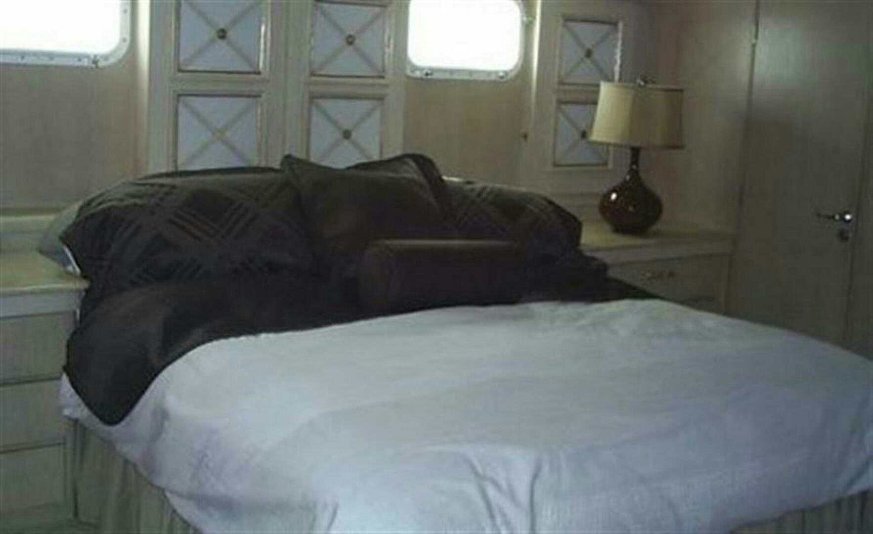 a bed with a black comforter aboard THE BEST DAY Yacht for Sale