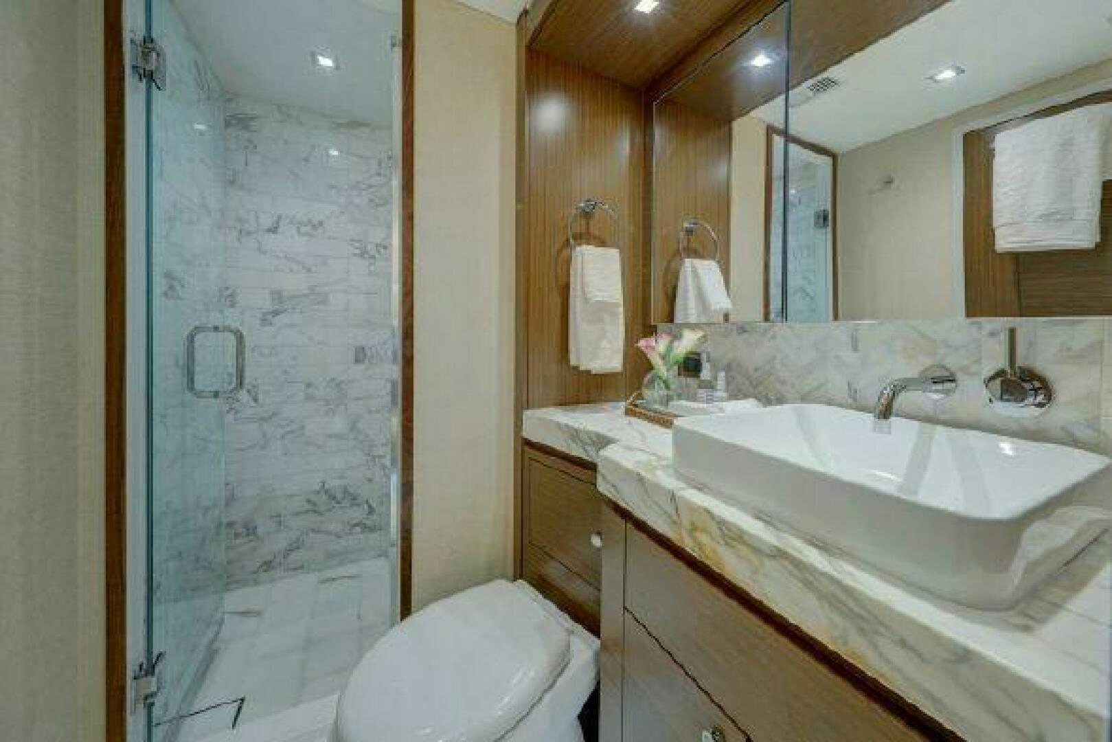 a bathroom with a sink and a mirror aboard 75 HATTERAS M75 / 2020 Yacht for Sale