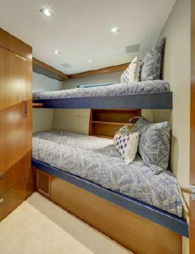 a bed with a blue comforter aboard 75 HATTERAS M75 / 2020 Yacht for Sale