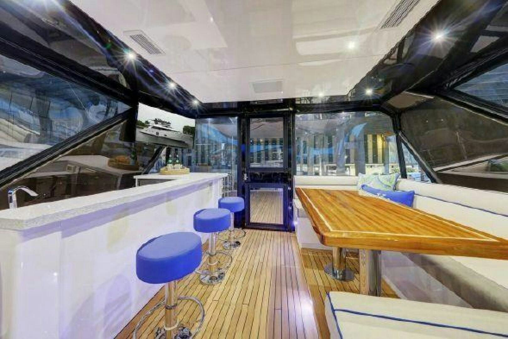 inside of a building with a wood floor and blue stools aboard 75 HATTERAS M75 / 2020 Yacht for Sale