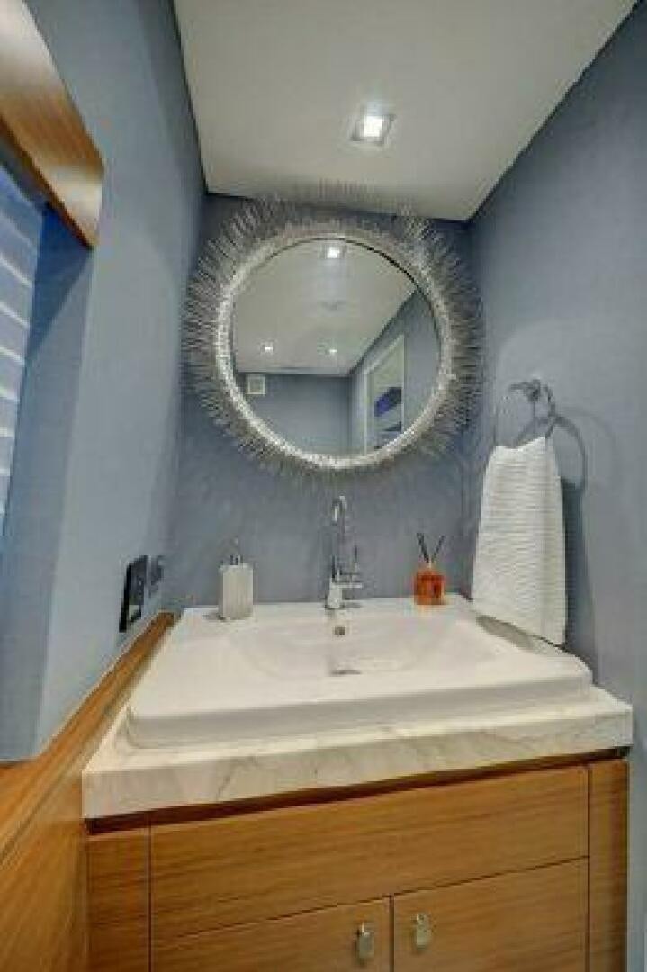 a bathroom with a round mirror aboard 75 HATTERAS M75 / 2020 Yacht for Sale