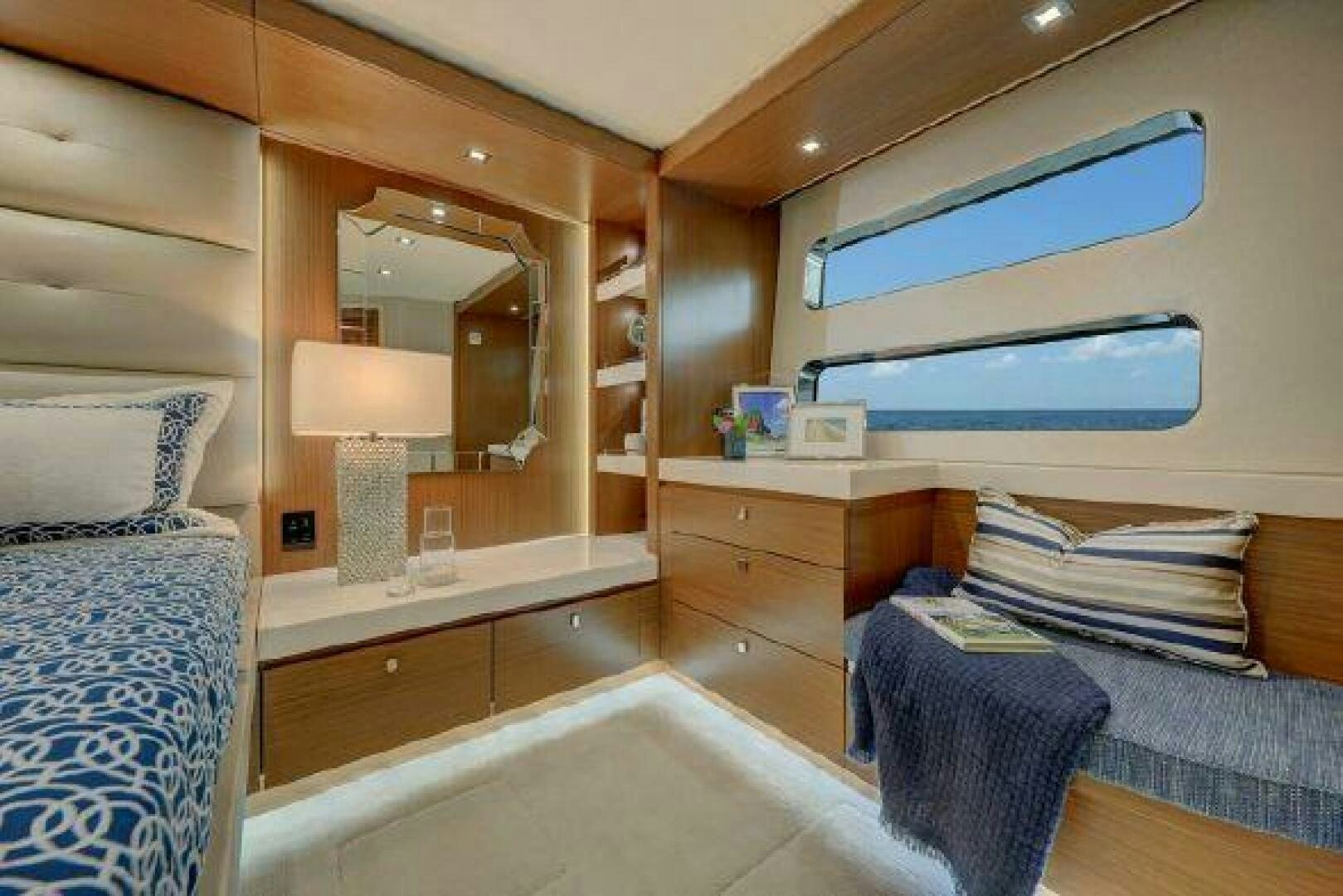 a room with a bed and a shelf with books on it aboard 75 HATTERAS M75 / 2020 Yacht for Sale
