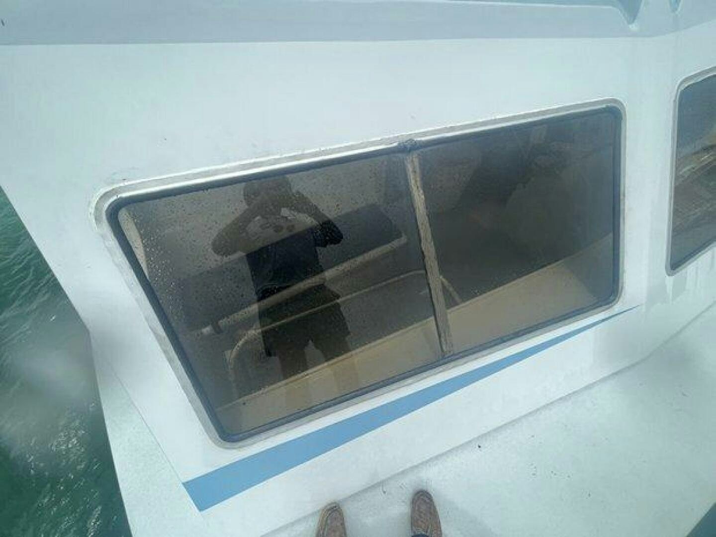 a person sitting in a window aboard EDGE 2 Yacht for Sale