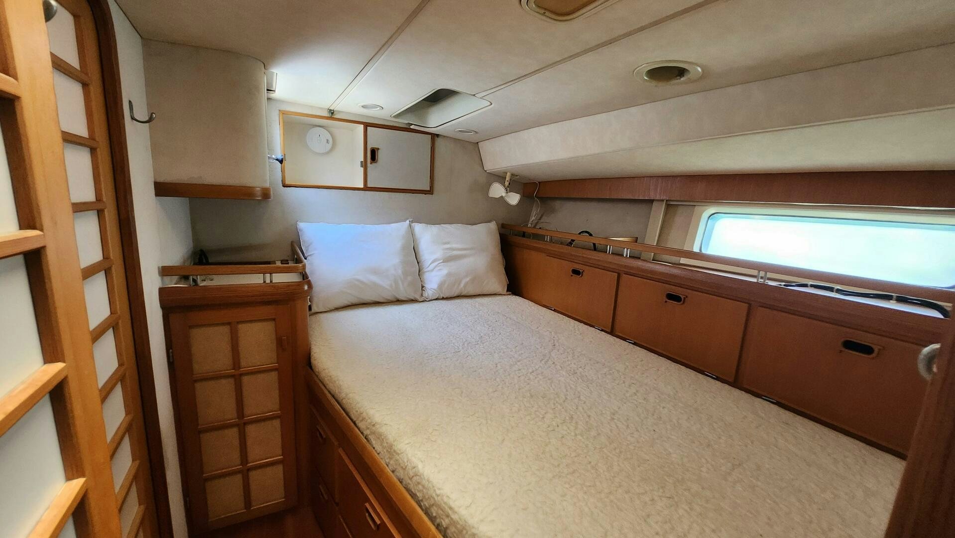 a bedroom with a bed and cabinets aboard MAYA Yacht for Sale