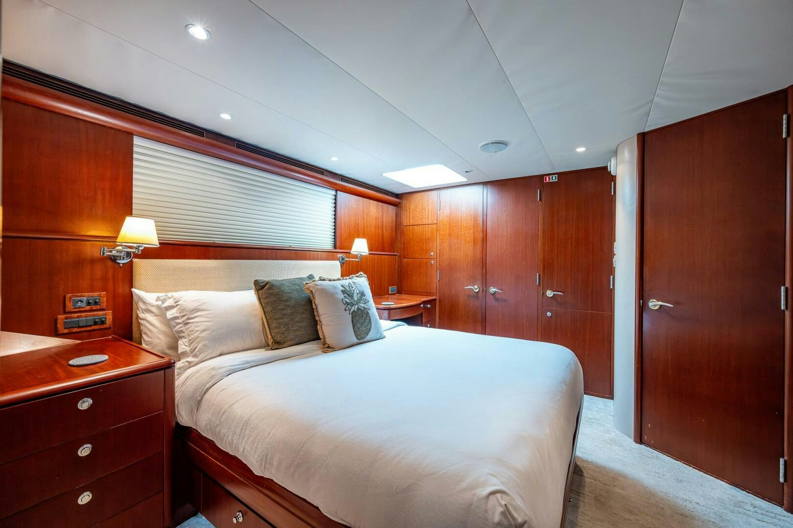 a bedroom with a bed and a wood cabinet aboard LADY LORRAINE Yacht for Sale