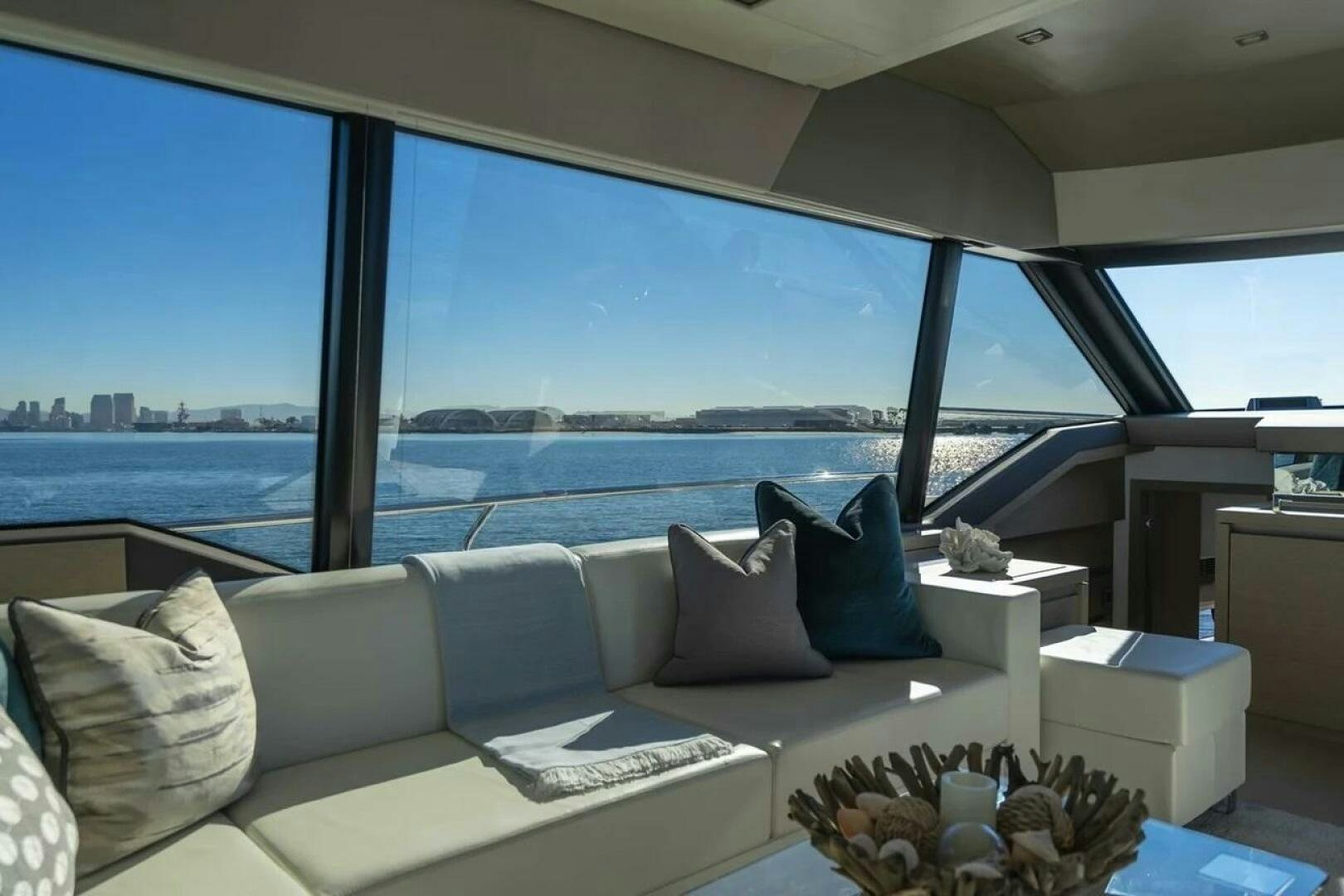 a couch and a table in a room with a view of the water aboard 5 STAR Yacht for Sale