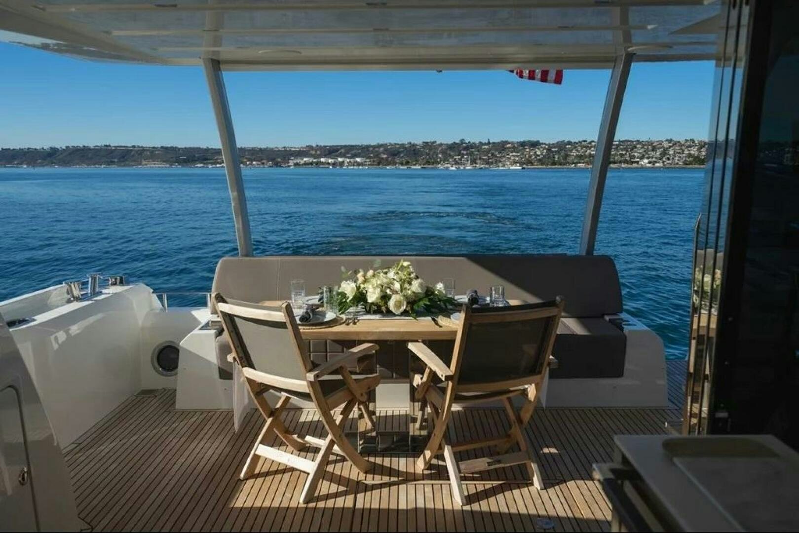a table and chairs on a deck overlooking a body of water aboard 5 STAR Yacht for Sale